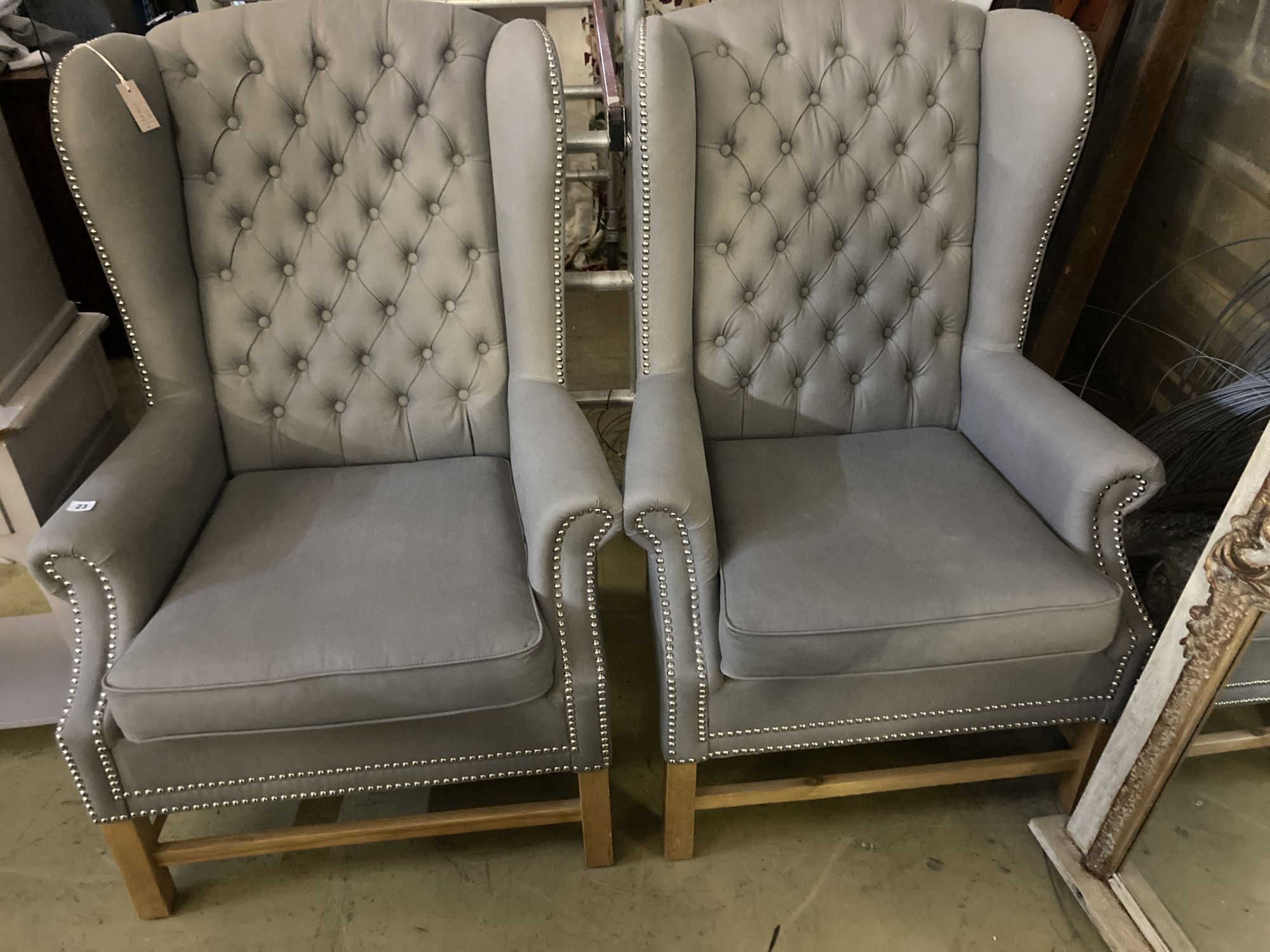 A pair of Victorian style wing armchairs, recently re-upholstered in buttoned grey fabric, width 82cm depth 78cm height 116cm